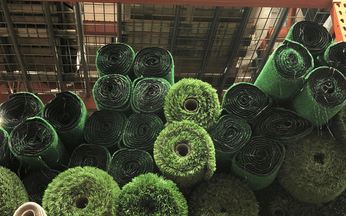 Rollos de césped artificial enrollado listos para instalación en obra exterior